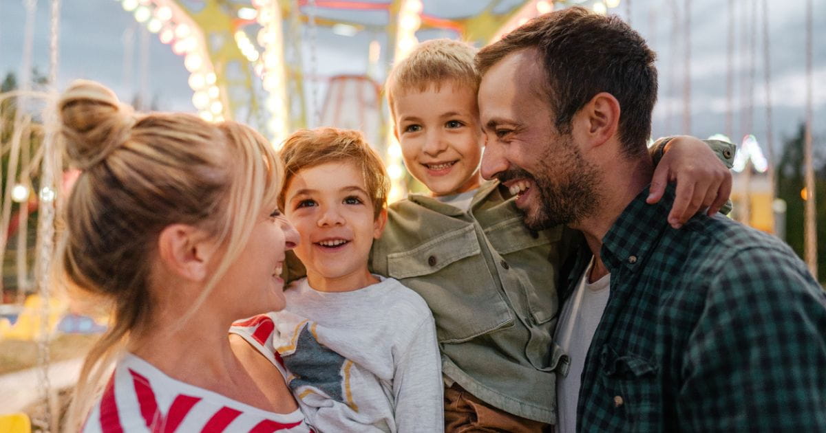 Stock image of a family on a funfair ride at a summer carnival