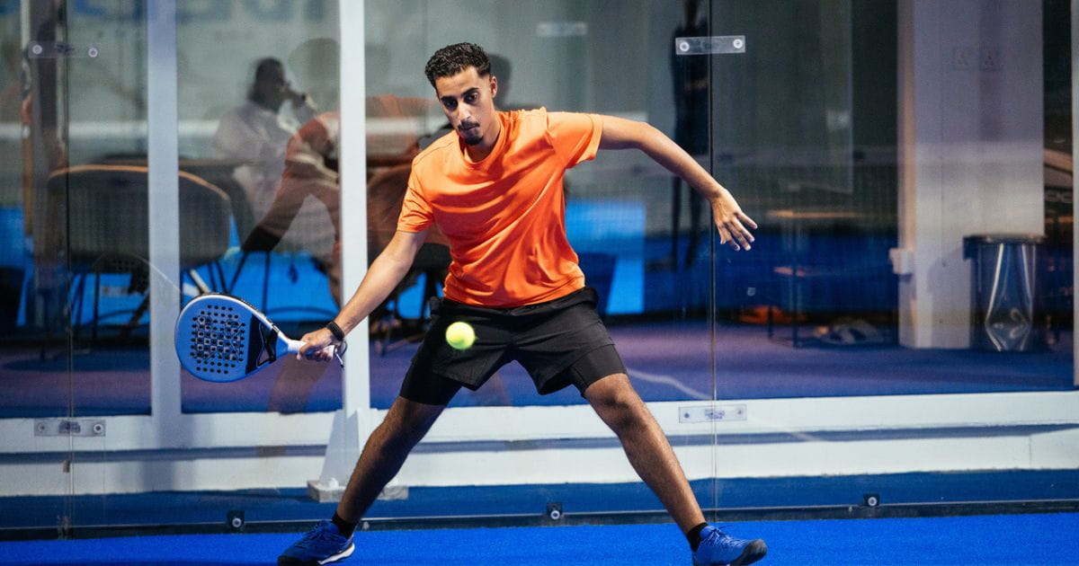 A man hits a ball during a game of padel